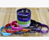 Colorful LED Wrist Watch bands stacked on a wooden surface, showcasing various styles and colors.